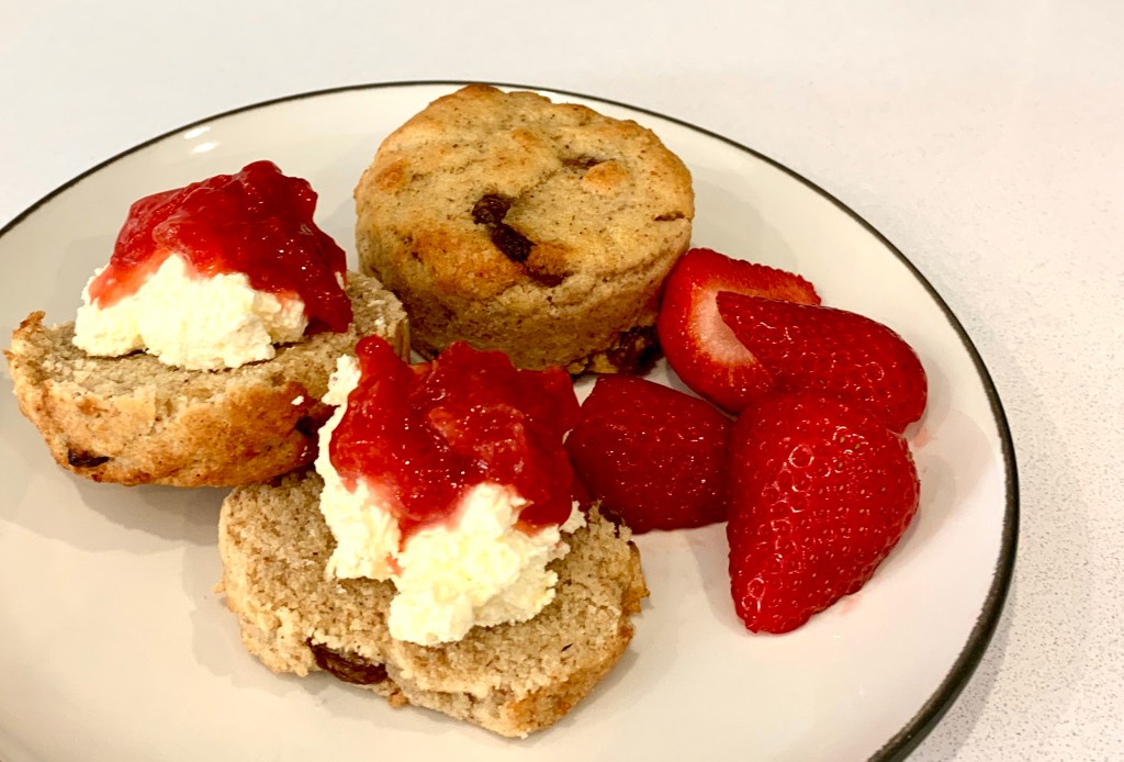 Keto scone with clotted cream, homemade strawberry jam and fresh strawberries