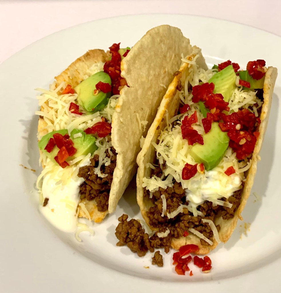 Keto tacos, filled with beef mince, grated cheese, avocado, chilli and sour cream