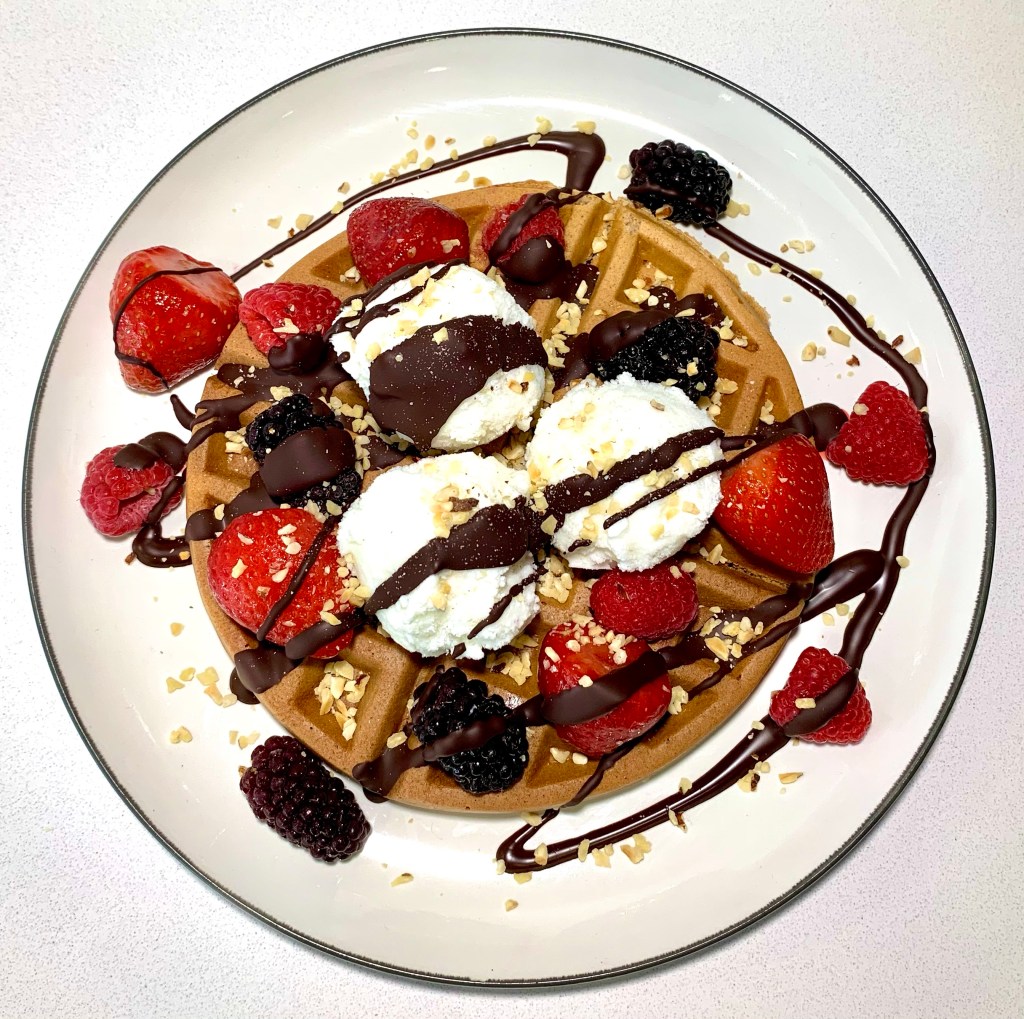 Keto sweet waffles, with vanilla ice cream, berries, melted chocolate and chopped nuts